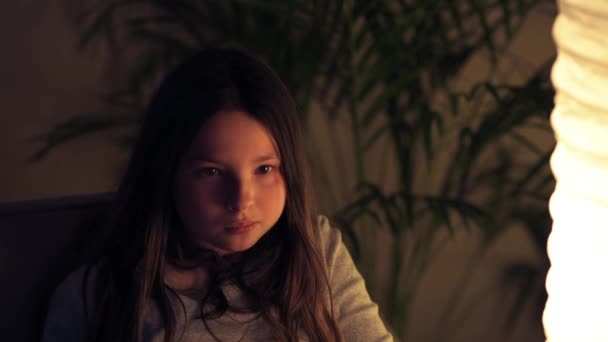TV 를 보는 귀여운 소녀, 무서운 영화, 소파에 앉아 있는 겁먹은 소녀. — 비디오