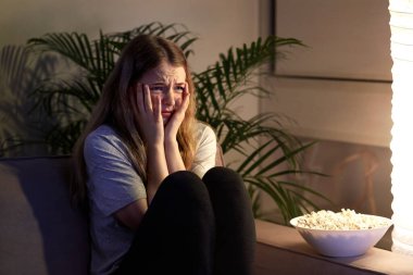 Korku filmi seyreden ve korkan kız. Patlamış mısırlı bir film izle..