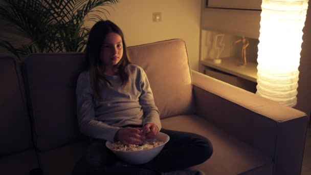 La fille a regardé un film effrayant et jette du pop-corn vers la télévision. — Video