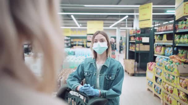 Twee mooie jonge meisjes vriendinnen ontmoetten elkaar in een winkel en praatten. — Stockvideo