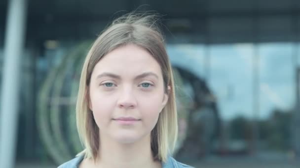 Närbild porträtt av en ung blond flicka som sätter på en medicinsk mask. — Stockvideo