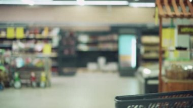 Yüzü maske takmış, alışveriş arabası olan bir kızın bulanık görüntüsü..