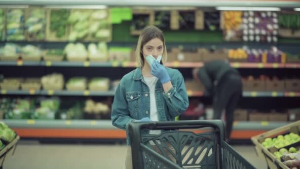 A rapariga de close-up põe uma máscara médica na cara numa loja. Compras seguras durante — Vídeo de Stock