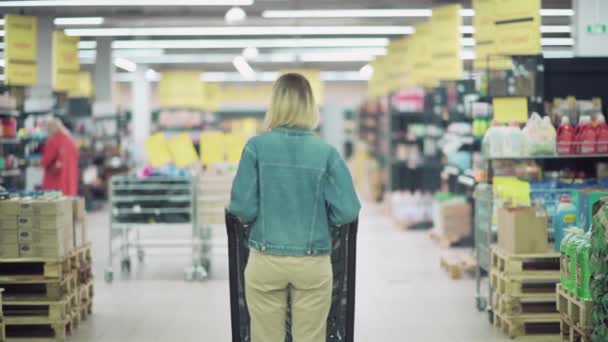 Blurred image of a young girl in a face mask with a shopping cart. — Stock Video