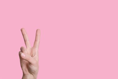 İki numara. Kadın eli parmaklarına güvenir. pembe arkaplan.