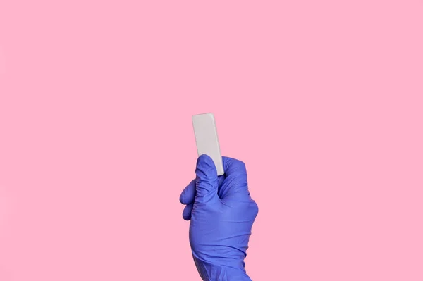 La mano de cerca en guantes de látex médico borra la información con un borrador . — Foto de Stock