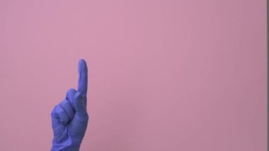 Bir adam elini sıhhiyeye uzatır, lateks eldivenle 1 'den 5' e kadar olan sayıları gösterir..