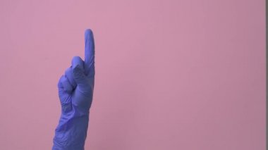 Tıbbi eldivendeki bir el sırayla sayıları gösterir. Bir, iki, üç, dört, beş..