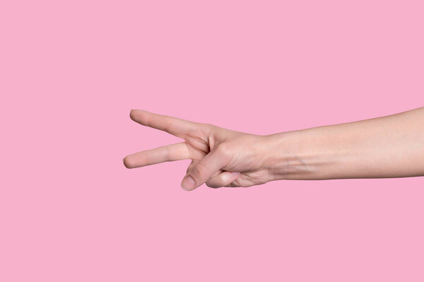 The number two. Caucasian hand, shows numbers on the fingers. on pink background