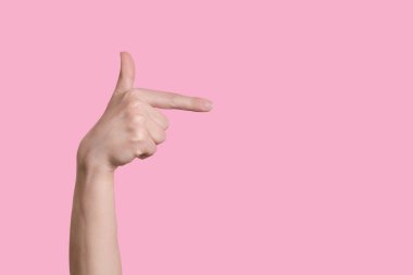 Bir el bir silah hareketi gösterir ya da sağa. izole edilmiş pembe arkaplan.