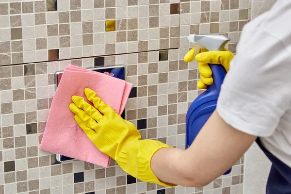 Aplicar el agente de limpieza al botón de agua en el inodoro y limpiar con un paño de limpieza . — Foto de Stock
