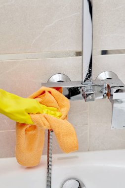 Profesyonel temizlikçi. Banyodaki musluğu kuru bir havluyla sil..