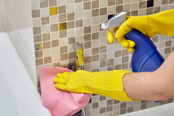 Apply household chemicals and wipe with a cleaning towel on a shower for a bidet