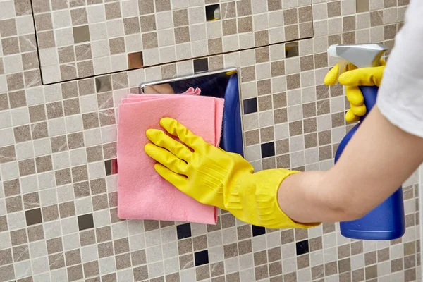 En las manos de un spray con productos químicos domésticos y un trapo para limpiar . — Foto de Stock