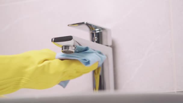 Primo piano di una mano in guanto di gomma lava il rubinetto in bagno. Senza volto. — Video Stock