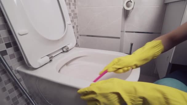 Gadis dari layanan pembersihan membersihkan toilet putih. Pembersihan profesional — Stok Video
