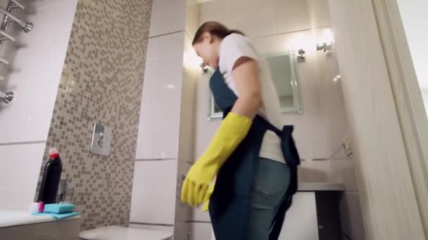 Dívka dává čistič na záchod. Ruce ve žlutých gumových rukavicích na čištění.