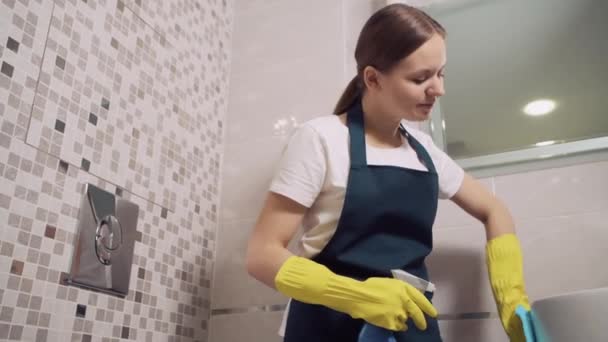 Schöne brünette Mädchen wäscht Wasserhahn im Badezimmer. Spray auf Waschbecken auftragen. — Stockvideo