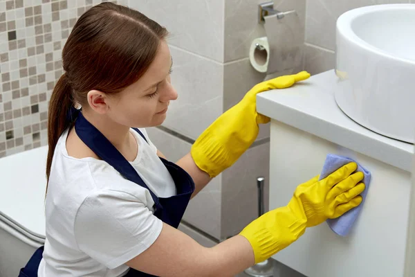Limpieza del baño por un limpiador profesional. Guantes de goma para limpiar . — Foto de Stock