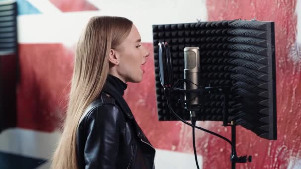 Le ragazze cantano in un microfono. Registrazione di una canzone in uno studio di registrazione. — Video Stock