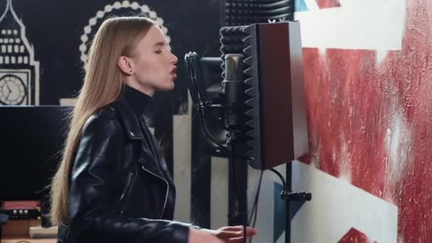 Las chicas cantan en un micrófono. Grabar una canción en un estudio de grabación . — Vídeos de Stock