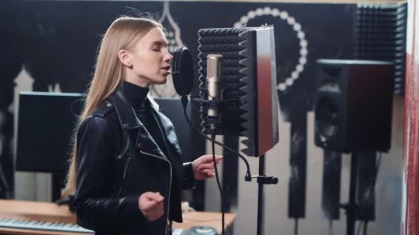 Gros plan de belle fille blonde enregistre une chanson dans un studio d'enregistrement. — Video