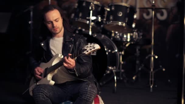 Guapo chico brutal con el pelo largo toca la guitarra electrónica . — Vídeos de Stock