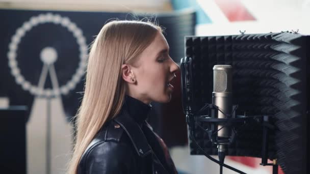 Hermosa chica rubia encantadora está grabando una canción en un estudio de grabación . — Vídeos de Stock