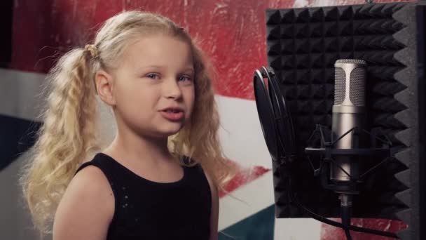 Мила дівчина з білим волоссям співає в мікрофон. Студія звукозапису . — стокове відео