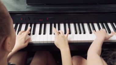 Piyano çalan kızların yakın çekimleri. Arkadan manzara..