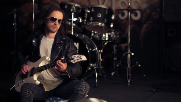 Um homem a tocar guitarra eléctrica. Brutal cara em óculos de sol . — Vídeo de Stock