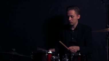 Profesyonel bir kayıt stüdyosundaki davul türünde bir kurulumun arkasındaki genç adam..