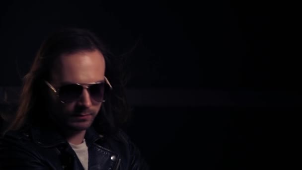 Handsome brutal adult man with long dark hair and dark glasses. — Stock Video
