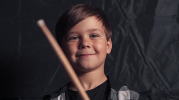 Un bel ragazzo sorridente sta suonando la batteria e guardando la telecamera. — Video Stock