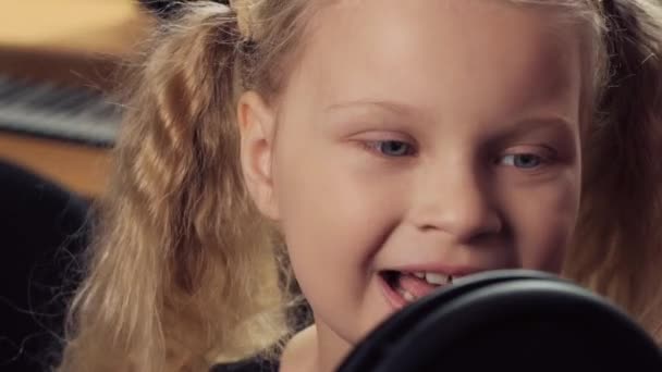 Detailní záběr na dívku. Roztomilá dívka s bílými vlasy zpívá do mikrofonu. — Stock video