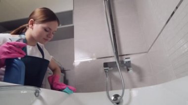 Spreyden banyoya ev kimyasalları sür. Banyoyu süngerle yıkar..