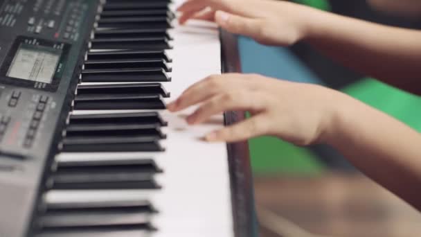 Närbild av barn händer på tangenterna till ett piano, synthesizer. — Stockvideo