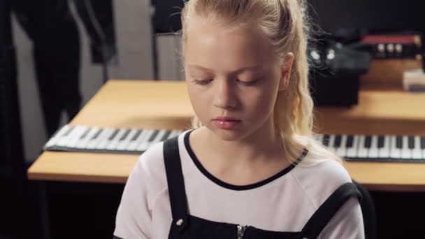 Detailní portrét mladé blondýny, která hraje na klavír. — Stock video