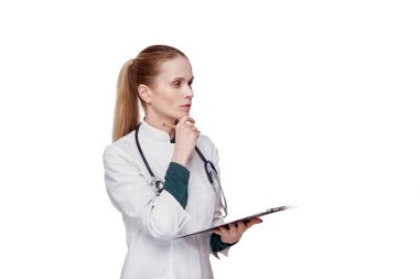 Doktor elinde bir dosya tutuyor ve hastaya hangi ilacı yazacağını düşünüyor..