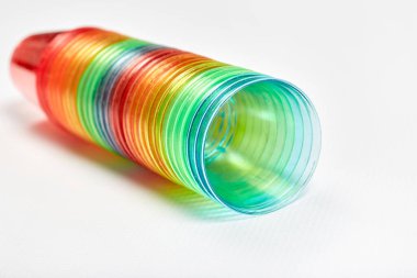 Birçok renkli plastik bardak bir araya istiflenmiştir. Gözlükler yalan söylüyor..