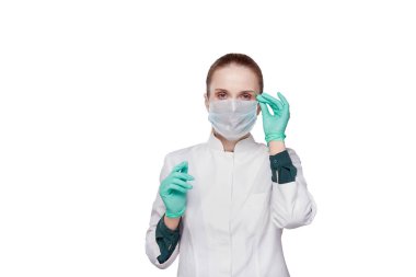 Kameraya bakan bir kadın doktor yüzüne tıbbi maske takıyor..