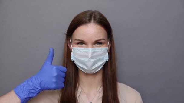 Donna in maschera protettiva mostra come segno — Video Stock