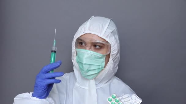 Woman in protective wear looks on pills — Stock Video