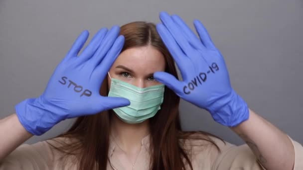 Γυναίκα με προστατευτική μάσκα και γάντια δείχνει στάση COVID-19 — Αρχείο Βίντεο