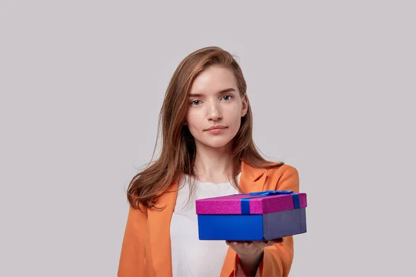 Девушка делает подарок в яркой коробке. Подарки на праздники . — стоковое фото