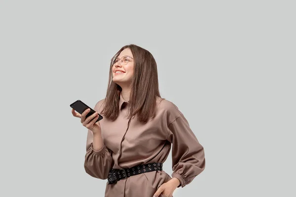 Snygg skrattande vacker affärskvinna med en mobiltelefon i händerna. — Stockfoto