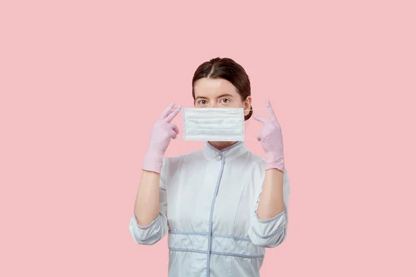 La chica sostiene una máscara cerca de su cara. Instrucciones sobre cómo usar una máscara en la cara — Foto de Stock