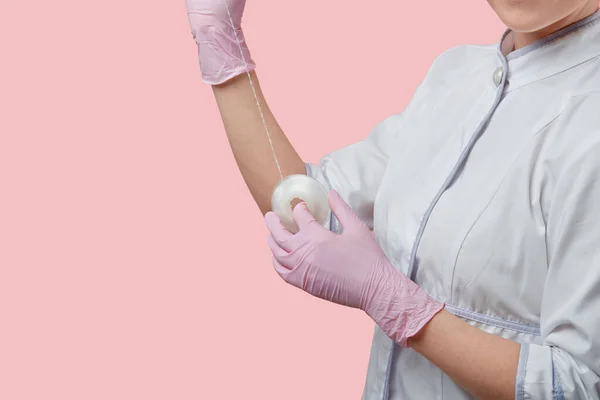 Handen in medische handschoenen houden tandzijde vast. — Stockfoto