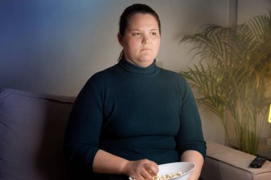 Televizyon izlerken mutsuz kız suratı. Yuvarlak suratlı kız.