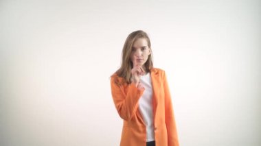 Kız sessiz bir jest yapıyor, dudaklarının yanında bir parmak. Kameraya bak..